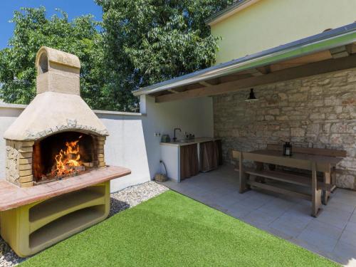 a patio with a pizza oven and a picnic table at Holiday Home Ana by Interhome in Bubani