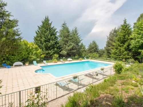 an image of a swimming pool with chairs and trees at Holiday Home La Châtaigneraie by Interhome in Aubazines