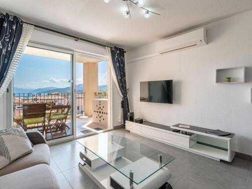een woonkamer met een glazen tafel en een televisie bij Apartment Clos des Oliviers by Interhome in LʼÎle-Rousse