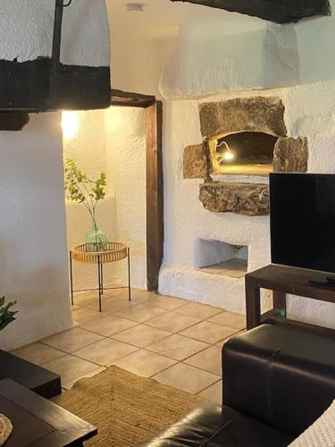 un salon avec une cheminée en pierre et une table dans l'établissement Spacious 1 bed home with shared pool, à Champagnac-la-Rivière