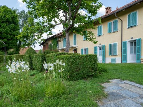 a house with a hedge and flowers in the yard at Holiday Home La Rocchetta 1915-2 by Interhome in Cortandone