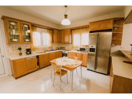 a kitchen with a table and a stainless steel refrigerator at Palailimnos in Palaiólimnos