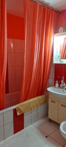 uma casa de banho com uma cortina de chuveiro laranja e um lavatório. em Casa Dorului 