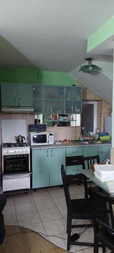 uma cozinha com armários verdes e uma mesa em Casa Dorului 