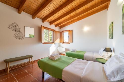 2 Betten in einem Zimmer mit Holzdecken in der Unterkunft Villa Oasis in Aljezur