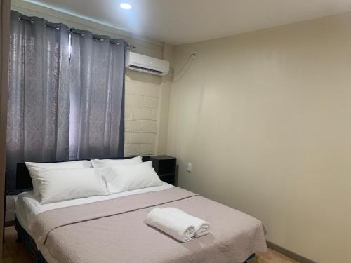 a bedroom with a bed with two towels on it at Samoa Business Apartments in Apia