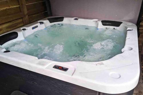 a jacuzzi tub with green water in it at Lovely 2 bed apartment with hot tub log burner and off street parking in Dumfries