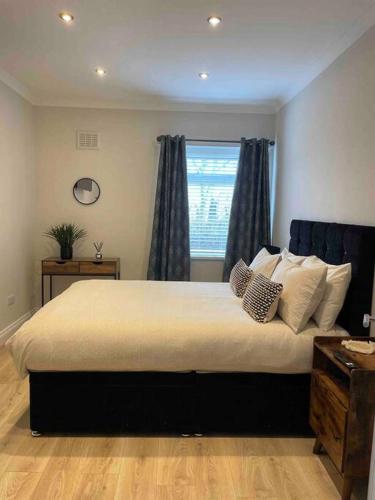 a bedroom with a large bed with a window at Lovely 2 bed apartment with hot tub log burner and off street parking in Dumfries