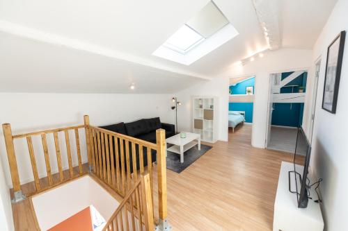 een loft appartement met een trap en een woonkamer bij KASA DUPLEX - Climatisation - Balcon - Parking Privé in Rive-de-Gier
