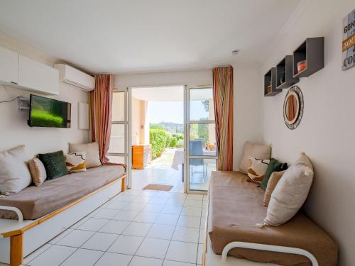 un salon avec deux canapés et un balcon dans l'établissement Apartment L'Esquinade - F6 015 by Interhome, à Agay