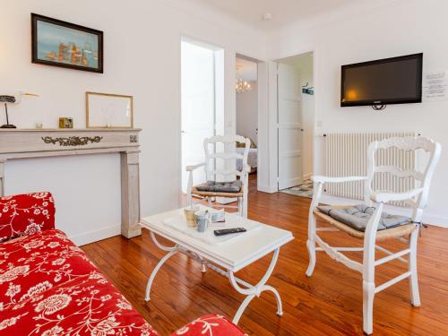 een woonkamer met een bank en stoelen en een open haard bij Holiday Home Le Colibri by Interhome in Cabourg