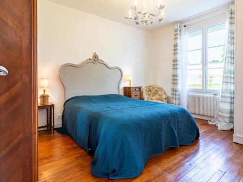 a bedroom with a large bed with a blue blanket at Holiday Home Le Colibri by Interhome in Cabourg