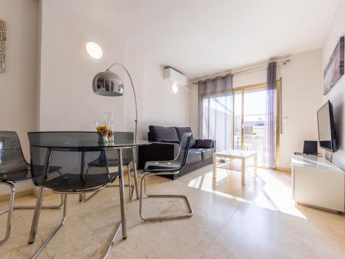 uma sala de estar com uma mesa preta e um sofá em Apartment Michelangelo-2 by Interhome em Salou