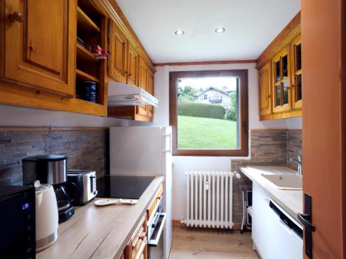 une cuisine avec des armoires en bois et une fenêtre dans l'établissement Apartment Le Nerey-2 by Interhome, à Saint-Gervais-les-Bains