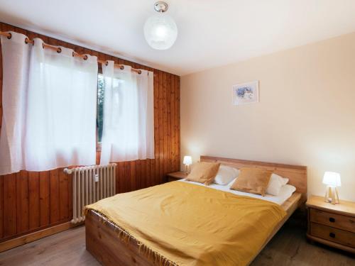 sypialnia z łóżkiem z żółtą pościelą i oknem w obiekcie Apartment Le Nerey-2 by Interhome w mieście Saint-Gervais-les-Bains