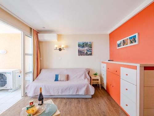 - une chambre avec des murs orange, un lit et une table dans l'établissement Apartment L'Esquinade - G3 122 by Interhome, à Saint-Raphaël