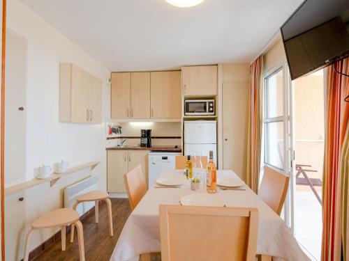 une cuisine et une salle à manger avec une table et des chaises dans l'établissement Apartment L'Esquinade - G3 122 by Interhome, à Saint-Raphaël