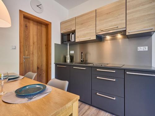 cocina con armarios azules y mesa de madera en Apartment Portášky- Velká Úpa 2 by Interhome, en Pec pod Sněžkou