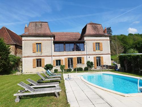 una casa con piscina frente a ella en Mas des maries, en Lissac et Mouret