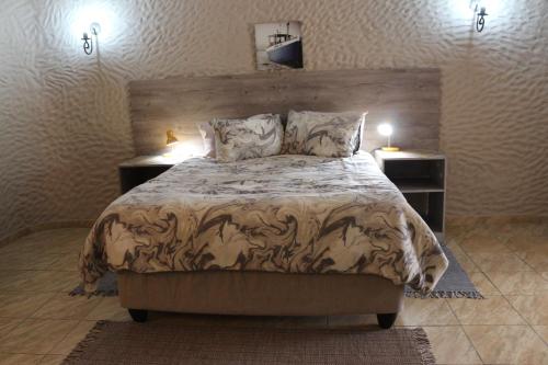 a bedroom with a large bed with two night stands at Amjicaja Guesthouse, Tours & Rentals in Walvis Bay