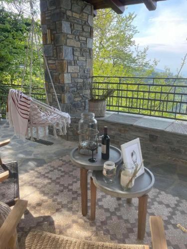 a table with a bottle of wine on a patio at Helene Eco Luxury Villa in Tsagarada