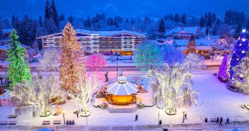 a resort with christmas trees and lights in the snow at Das Tree Haus by NW Comfy Cabins in Leavenworth