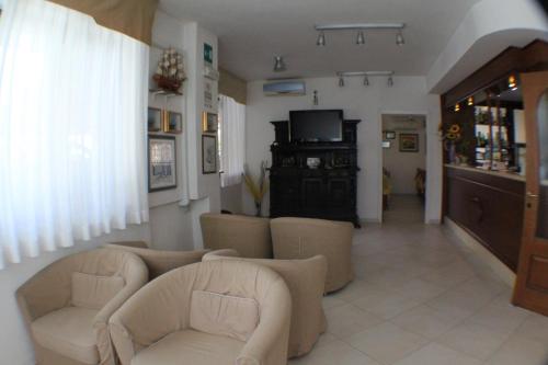 a living room with two chairs and a television at Hotel Europa in Albissola Marina