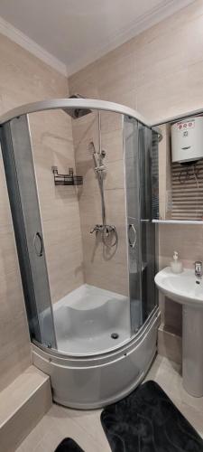 um chuveiro na casa de banho com um lavatório em Апартаменты ЦО Радуга (шикарный вид) em Chon-Sary-Oy