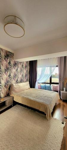 um quarto com uma cama grande e uma janela grande em Апартаменты ЦО Радуга (шикарный вид) em Chon-Sary-Oy