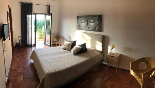 a bedroom with a bed and a table and chairs at Quinta das Amendoeiras B&B in Nora