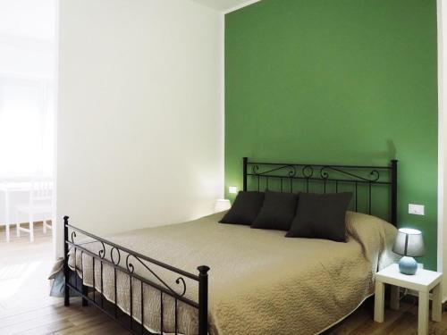 a bedroom with a bed with a green wall at HOTEL RESIDENCE VILLA NINA in Spotorno