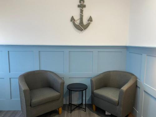 duas cadeiras e um relógio numa sala de espera em Marina Studio em Irvine