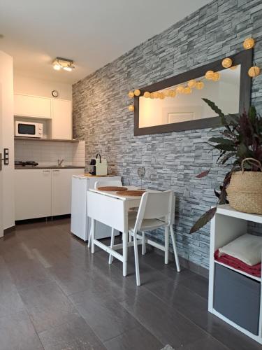 una cucina con tavolo, sedie e muro di mattoni di La Ribasse en Provence a Venelles