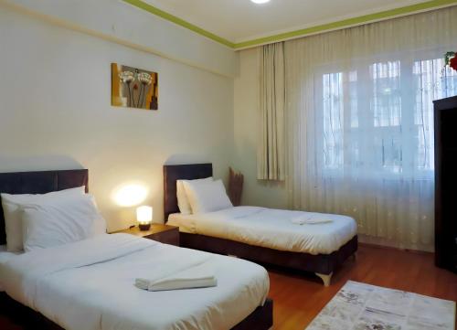 a hotel room with two beds and a window at Central and Serene Flat with Balcony in Antalya in Antalya