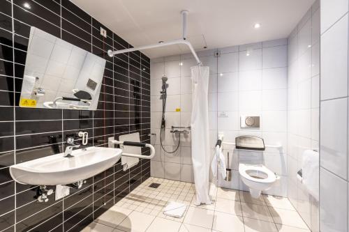 a bathroom with a sink and a toilet at Premier Inn Düsseldorf City Centre in Düsseldorf