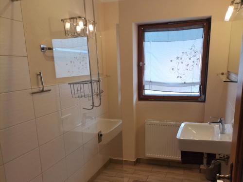 a bathroom with a sink and a tub and a window at Ferienwohnung Hochstaufen - Chiemgau Karte in Inzell