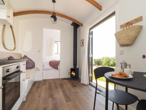 a kitchen and dining room with a table and a stove at Little Pip in Penzance