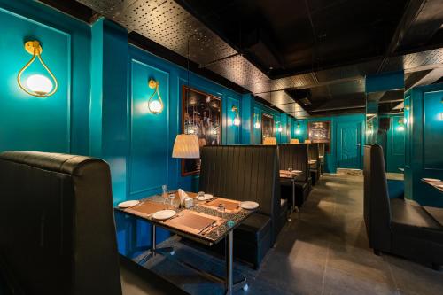a dining room with blue walls and a table and chairs at Rolling space in Puducherry