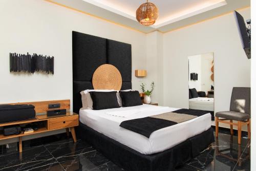 Un dormitorio con una cama grande y un televisor. en Angelica's Deluxe Rooms in Adamas, en Adamas