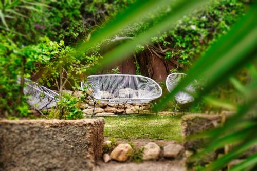 two white chairs sitting in the grass in a garden at Signature Agadir Villa Luxe for 4 or 6 PX in Agadir