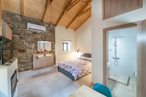 - une chambre avec un lit et un mur en pierre dans l'établissement Fotoula's stone studio, 