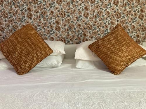 a bed with two brown pillows on top of it at Casa Gallinera in Benissiva