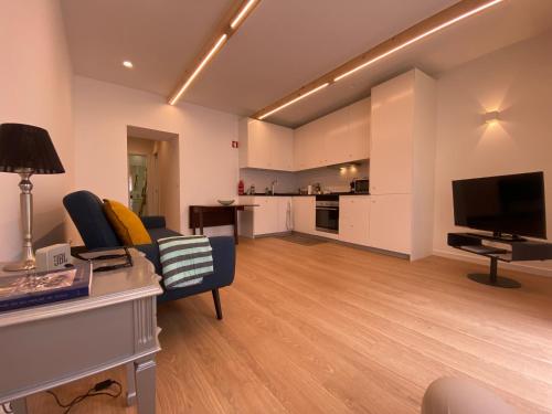 a living room with a couch and a television at Ó Maria in Alcácer do Sal