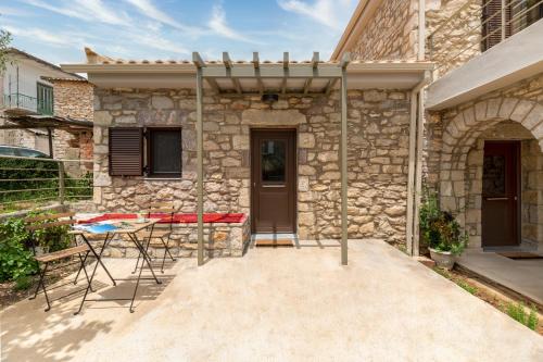 a stone house with a table and chairs outside at Fotoula's stone studio in Groustésion