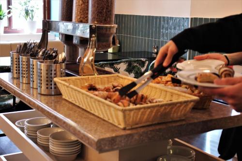 ブダペストにあるMade Inn Budapestのカウンターの籠の中で調理する者