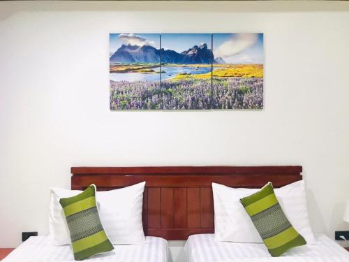 a bedroom with two beds and a painting on the wall at Benetti house in Patong Beach