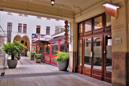 an empty street in a city with potted plants at Made Inn Budapest in Budapest