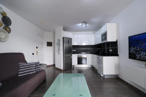 Una sala de estar con un sofá y una mesa de cristal. en Beachview Haven Apartment 1-BR, en Playa del Cura