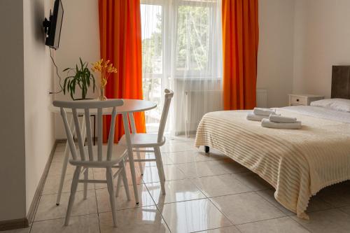 a bedroom with a bed and a table and chairs at TREND HOUSE Apartments & Hostel in Vinnytsya