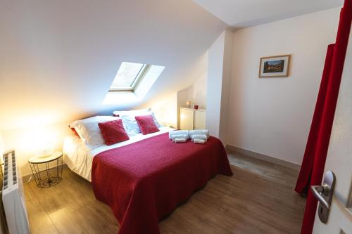 a bedroom with a bed with red sheets and a window at Le Pont Royal in Amboise